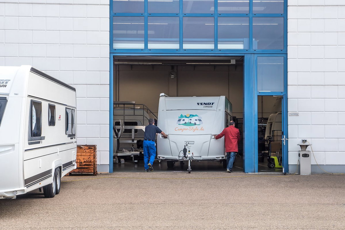 Wohnwagen wird in die Werkstatt geschoben.