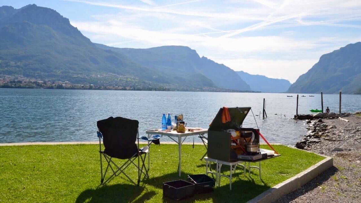 Ein gedeckter Picknicktisch an einem See beim Camping in Italien