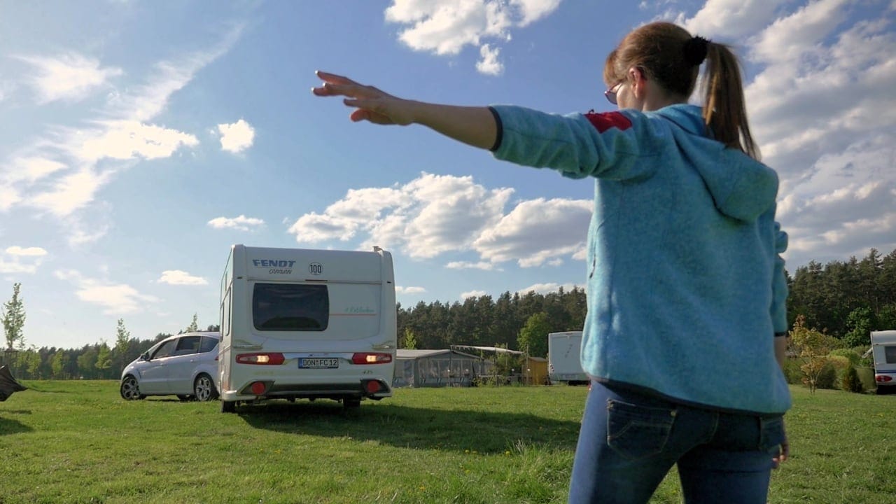 Eine Frau beim Einweisen eines Campers