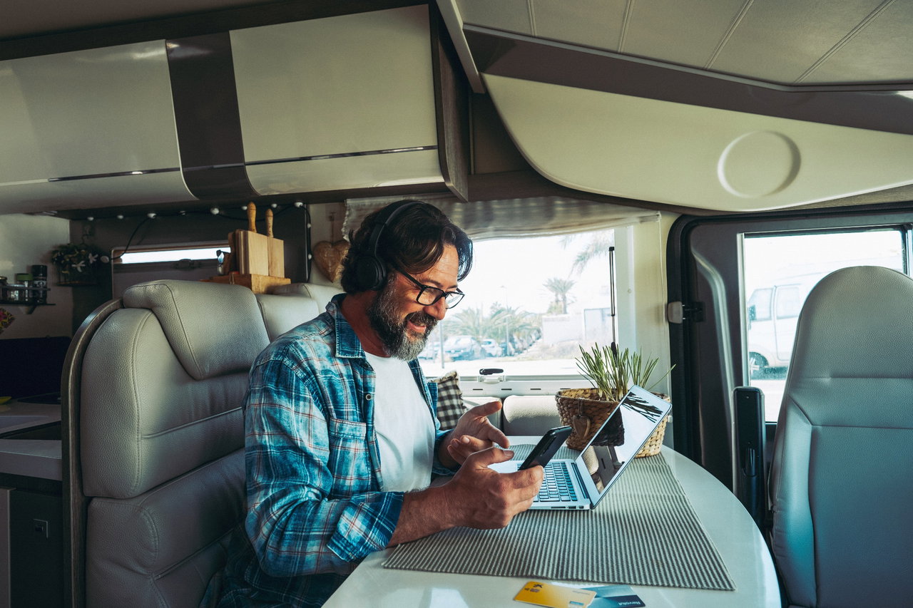Wohnmobil mobiles Office Mann am Tisch mit Laptop