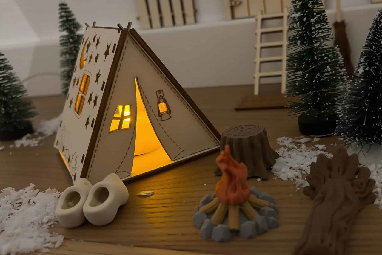 Stimmungsvolle Weihnachtsdeko im Camper, inklusive Lichterkulisse, Mini-Tannenbäume und Kerzen auf Holz.